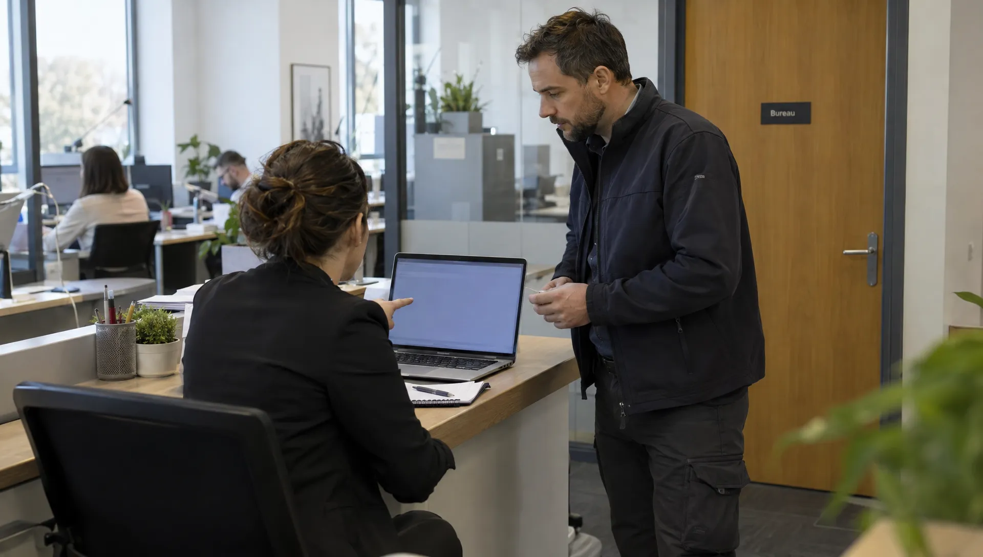 Une responsable informatique et un prestataire vérifient ensemble l’autorisation d’un accès distant à un poste professionnel.